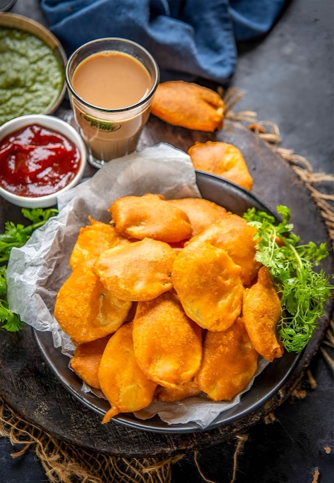 Knusprige Pakoras serviert mit Chutney und Chai